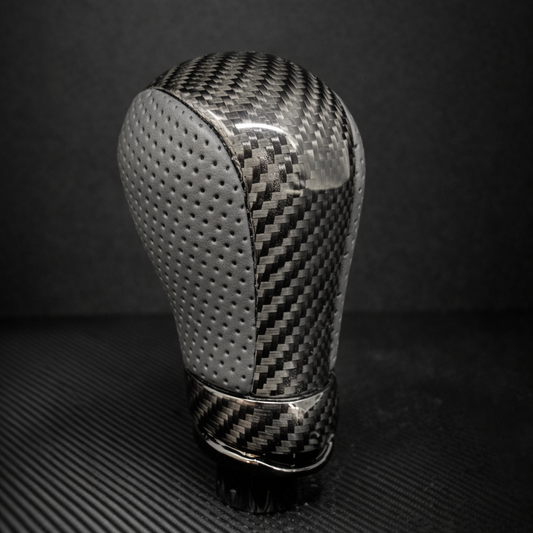 Carbon fiber gear shift knob on a dark background
